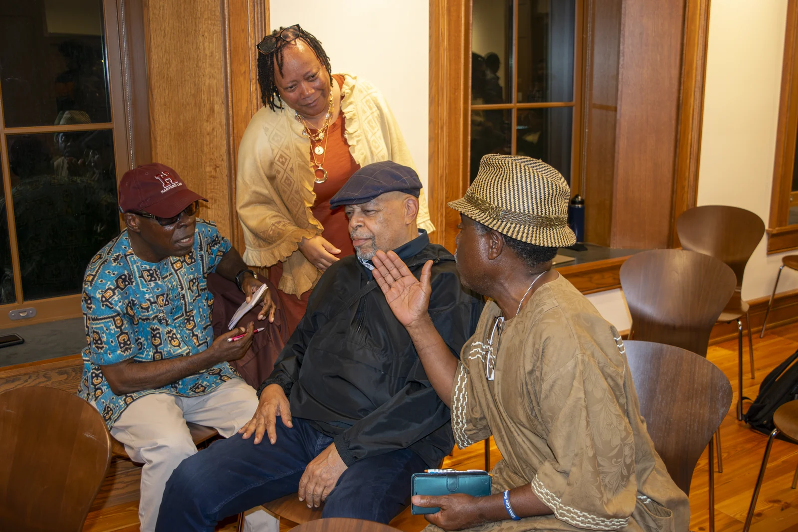 Around the table: Dr. Zizwe Poe, center; Dr. Michael Ayewoh, to his left; Dr. Chieke Ihejirika, to his right; and Mrs. Poe, standing.