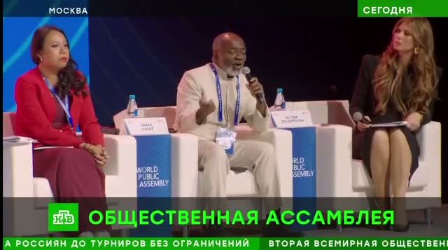 Dr. Gnaka Lagoke speaking into a microphone during the World Public Assembly panel